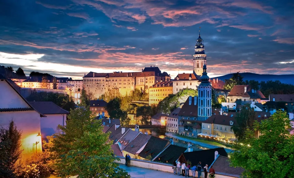 Český Krumlov při západu slunce s osvětlenou zámeckou věží